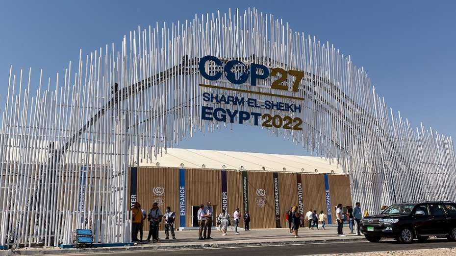 مدخل مؤتمر الأمم المتحدة لتغير المناخ (COP27) في مدينة شرم الشيخ بمصر عام 2022، حيث يظهر شعار المؤتمر والوفود الدولية وهي تدخل القاعة الرئيسية.