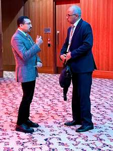 المحامي محمود جابر أثناء نقاش ودي مع السفير كمال بشير خلال القمة العالمية للتنمية الاجتماعية في الدوحة