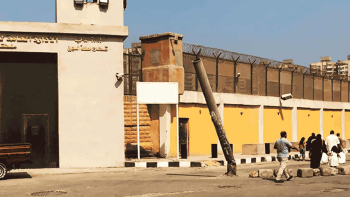 واجهة سجن طرة شديد الحراسة في مصر مع ظهور زوّار يقفون أمام البوابة الرئيسية