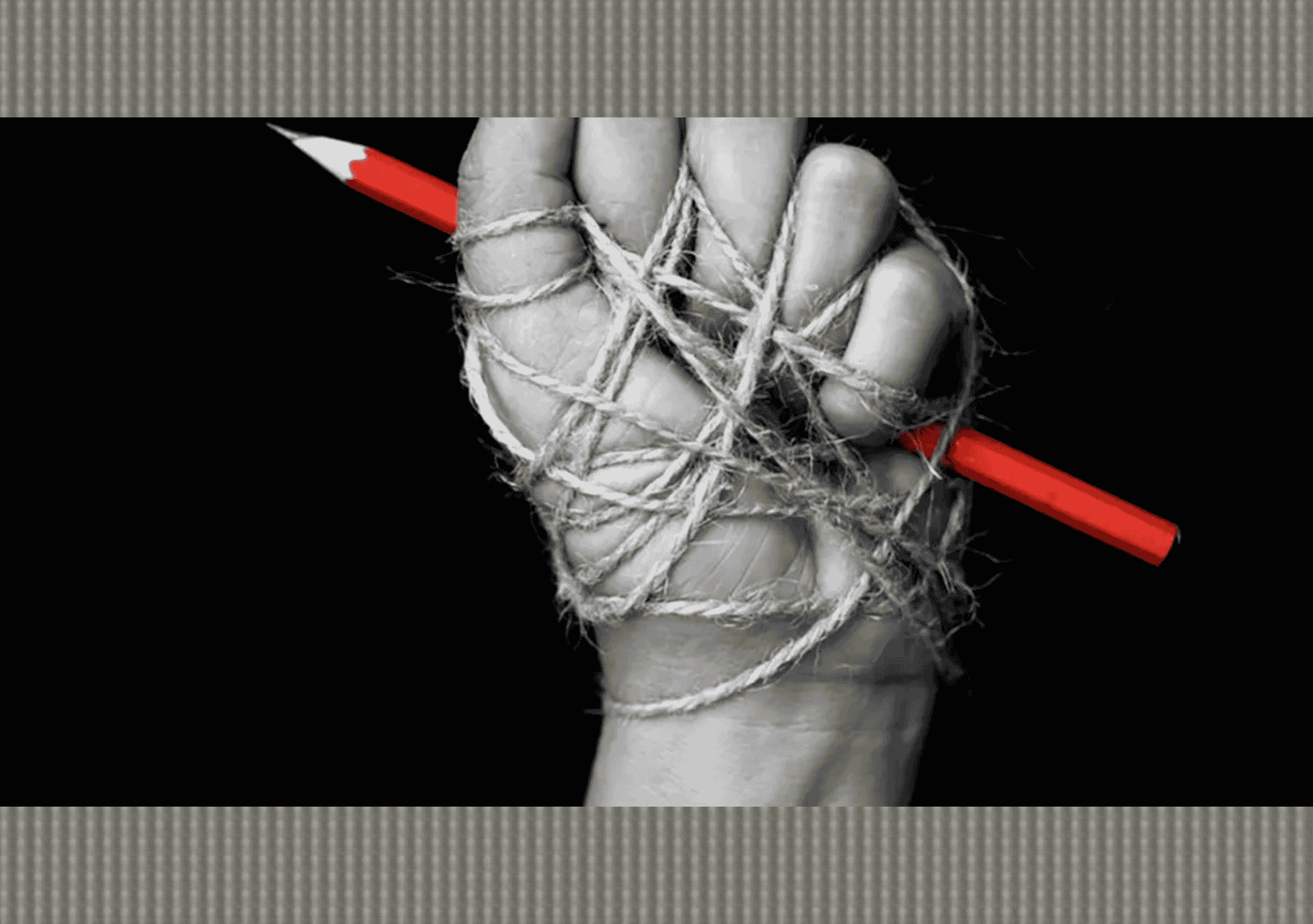 يد مقيّدة بالحبال تمسك قلمًا أحمر في مشهد يرمز لقمع حرية الصحافة والتعبير.