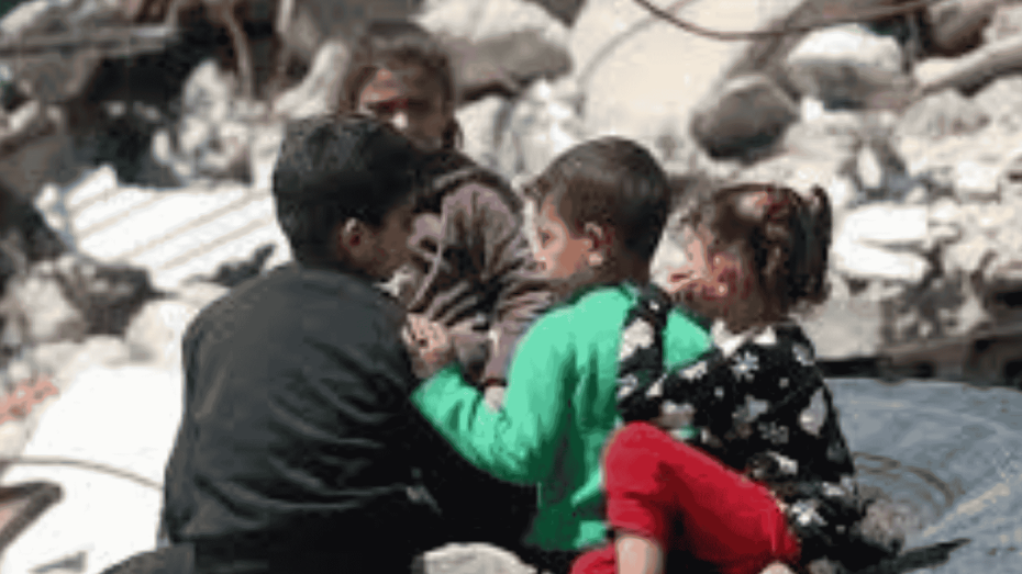 أطفال يجلسون بين الركام في منطقة مدمرة، يعانون من آثار النزاع والدمار.