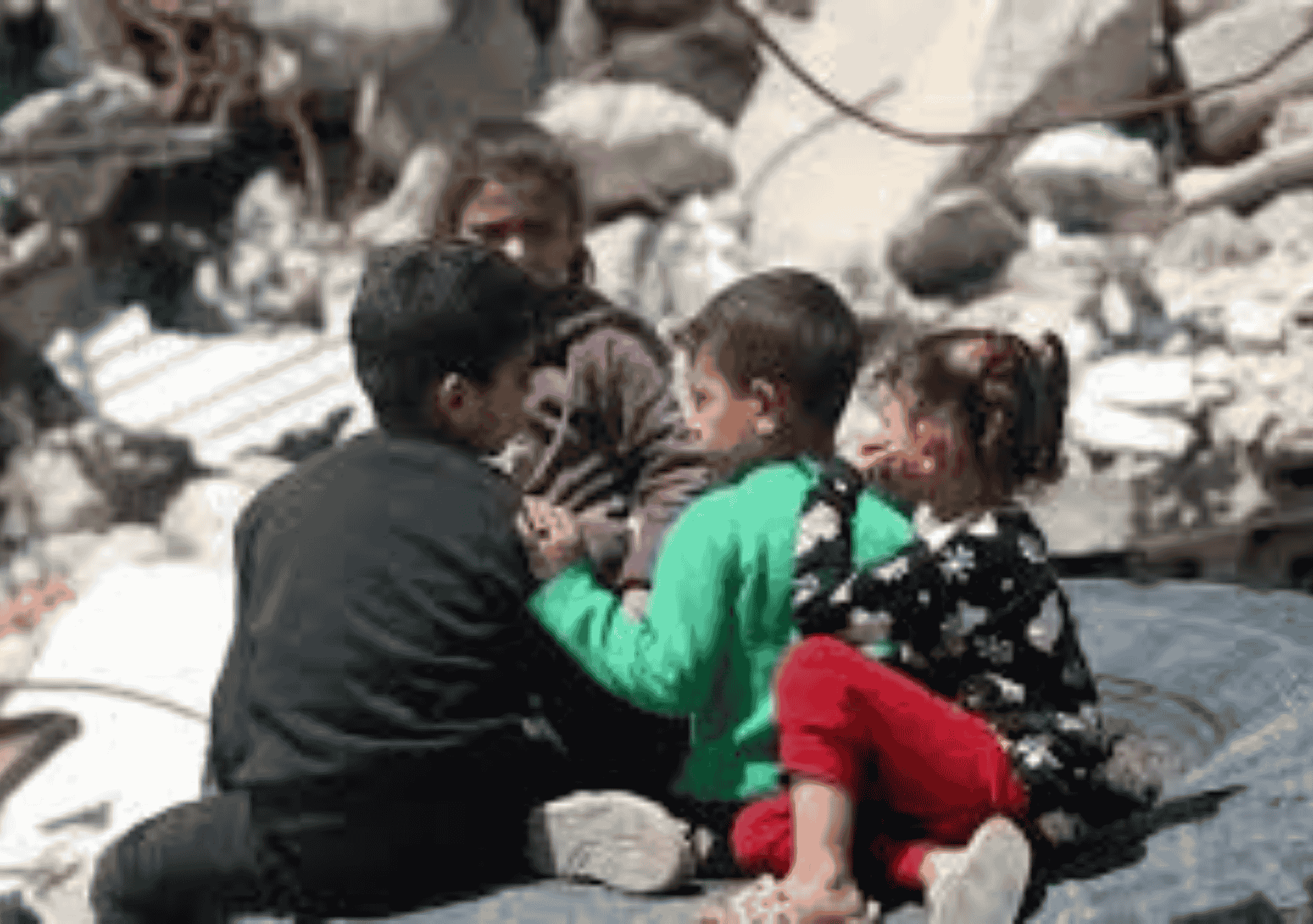 أطفال يجلسون بين الركام في منطقة مدمرة، يعانون من آثار النزاع والدمار.