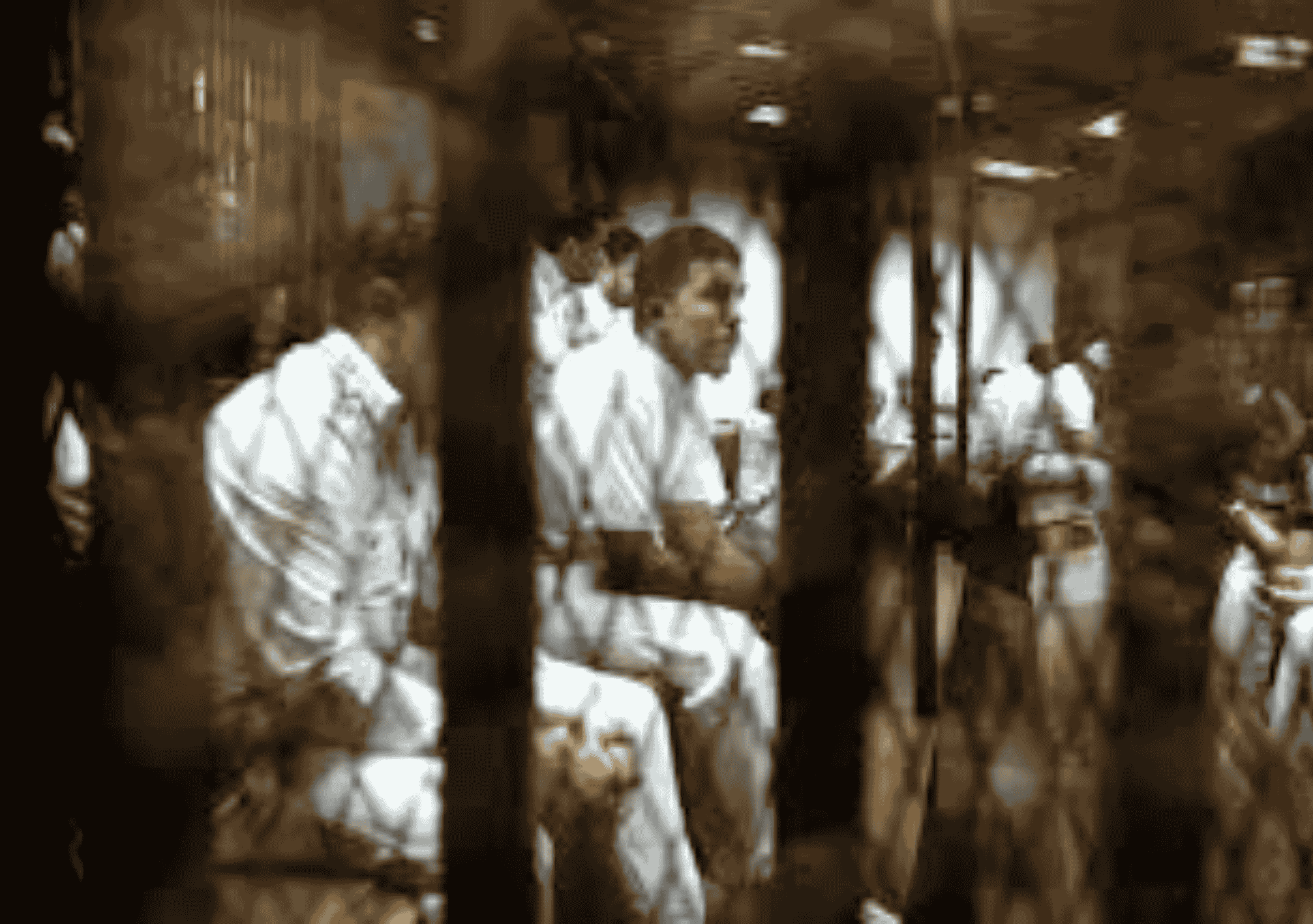 متهمون داخل قفص المحكمة في إحدى الجلسات بمصر يرتدون الزي الأبيض ويظهرون خلف الحواجز الحديدية.