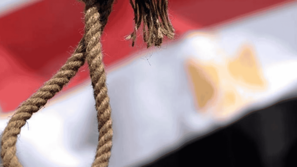 حبل مشنقة يتدلّى في مقدمة الصورة وخلفه العلم المصري بشكل غير واضح.