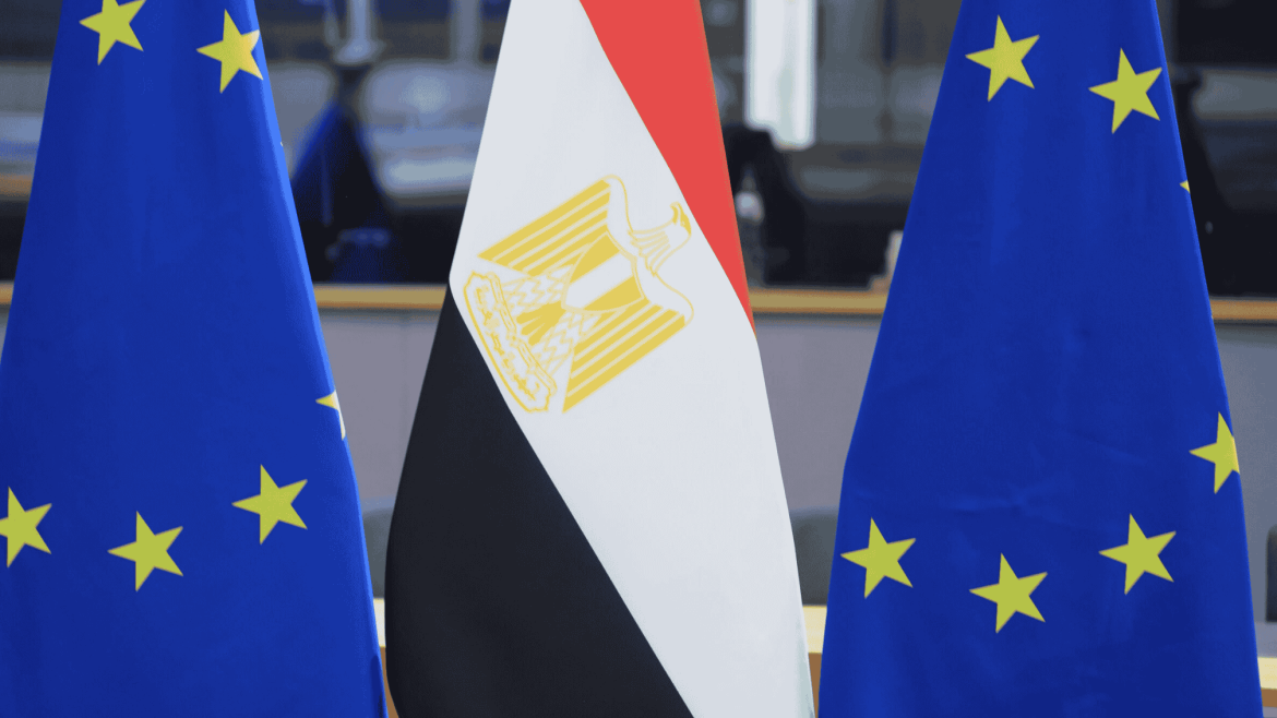 أعلام الاتحاد الأوروبي ومصر مصطفة جنبًا إلى جنب في قاعة رسمية.