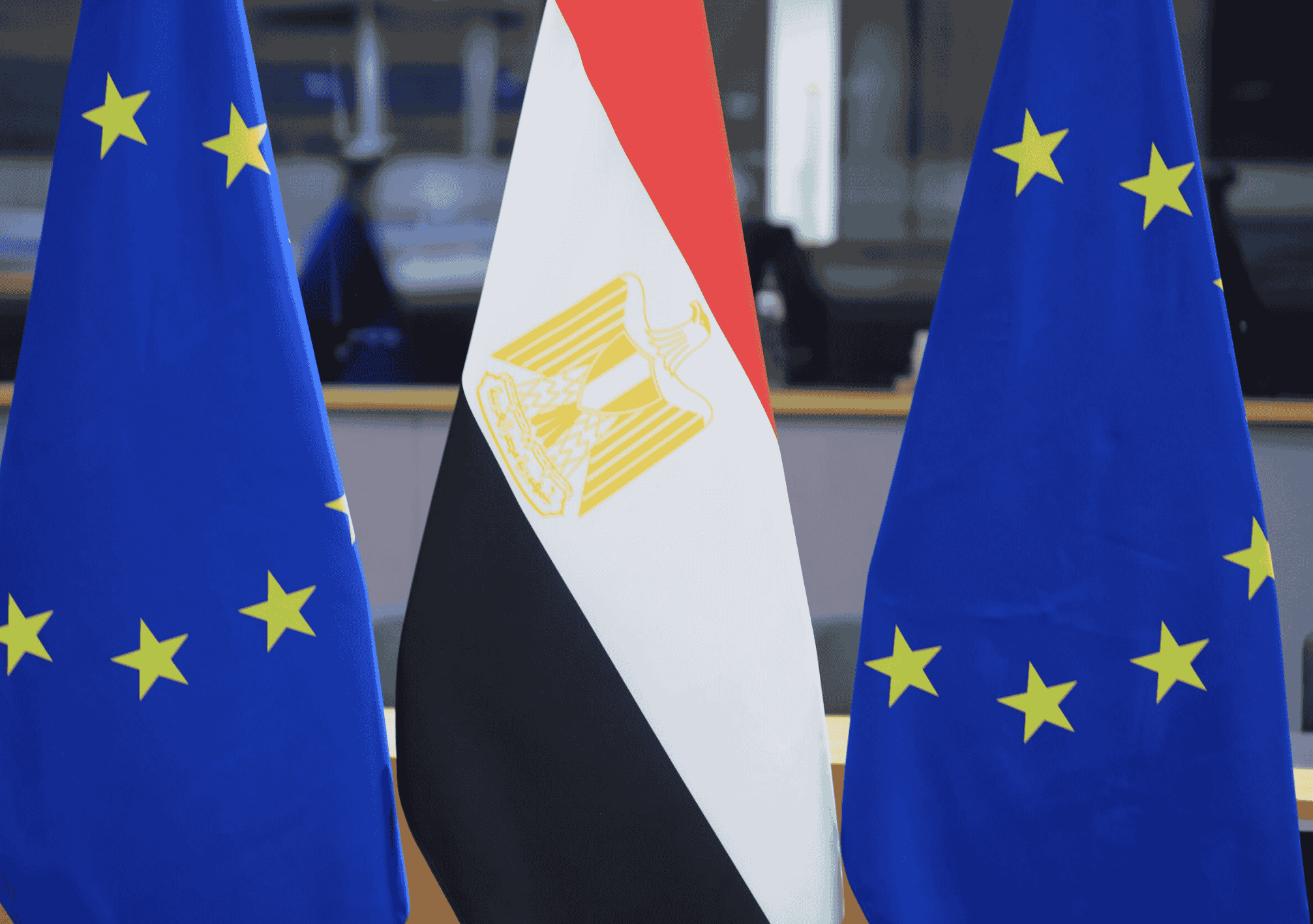 أعلام الاتحاد الأوروبي ومصر مصطفة جنبًا إلى جنب في قاعة رسمية.