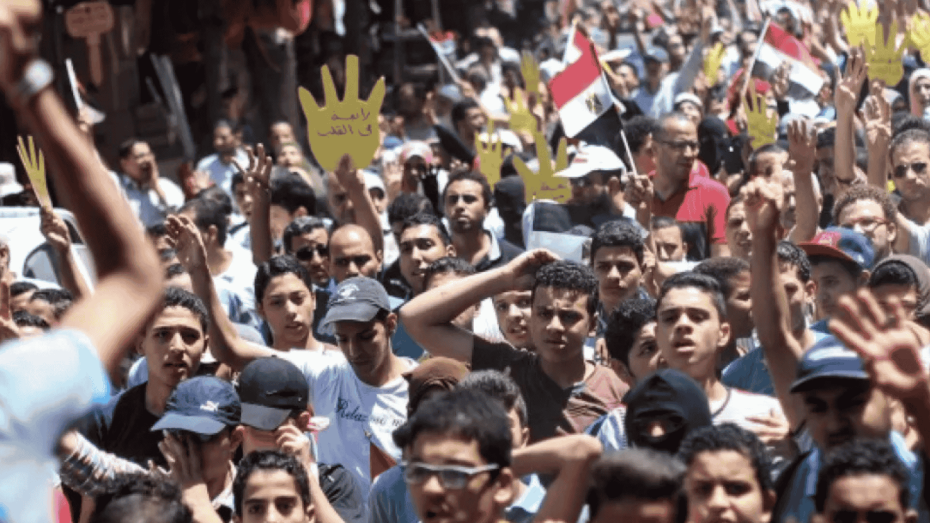 صورة لمتظاهرين في أحد شوارع مصر يرفعون لافتات صفراء وأعلامًا مصرية، تعبيرًا عن احتجاجهم على الانتهاكات الحقوقية والمطالبة بالحرية والعدالة.